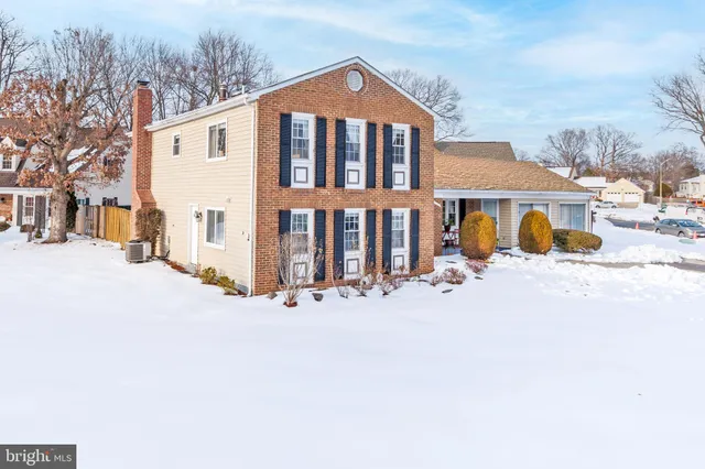 a front view of a house with a yard covered with snow