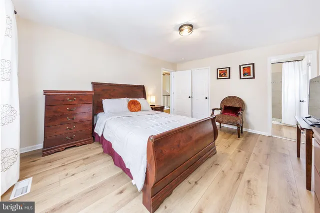 a bedroom with a bed and wooden floor