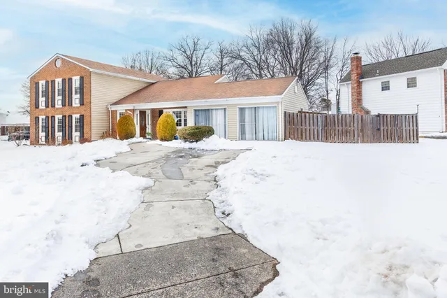 a view of residential houses with snow on the road