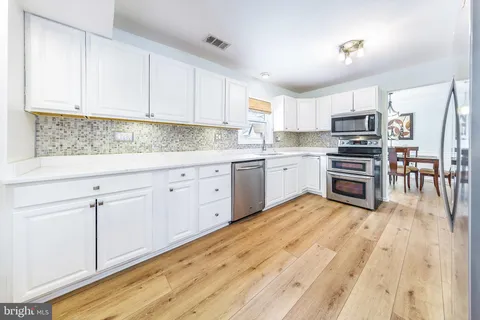 a kitchen with stainless steel appliances a refrigerator and a stove top oven