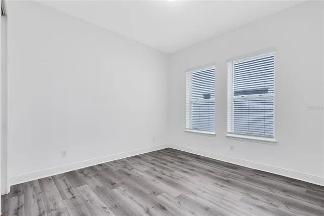 an empty room with wooden floor and a window