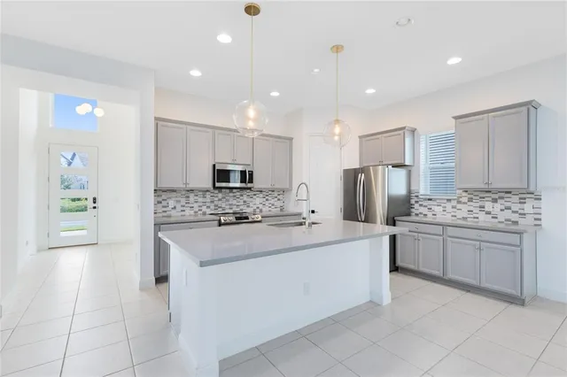 a kitchen with stainless steel appliances kitchen island granite countertop a refrigerator and a stove top oven