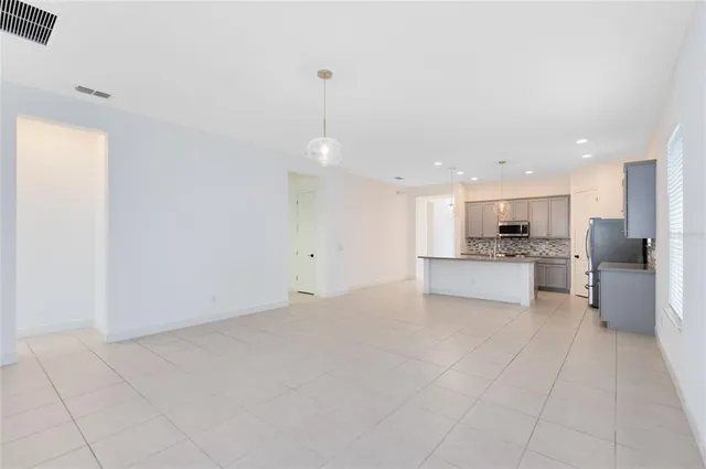 a view of kitchen with granite countertop cabinets and refrigerator