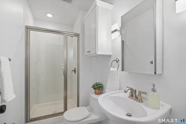 a bathroom with a sink toilet and shower