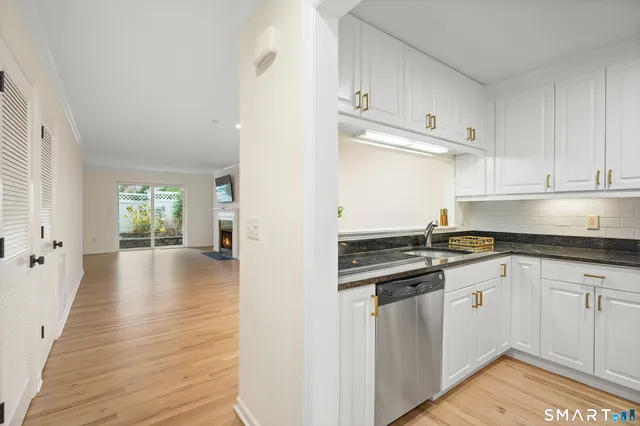 a kitchen with granite countertop a stove and white cabinets
