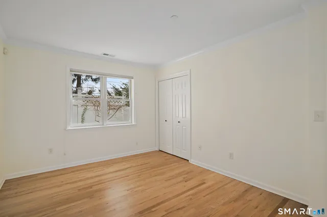 an empty room with wooden floor and window