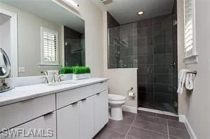 a bathroom with a double vanity sink toilet and shower