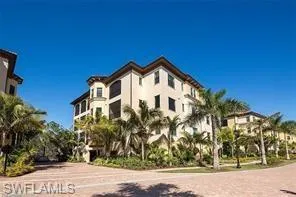 front view of house with a yard and palm trees
