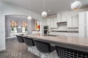 a kitchen with stainless steel appliances granite countertop a stove a sink and a white cabinets