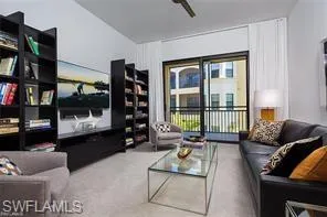 a living room with furniture a flat screen tv and a large window