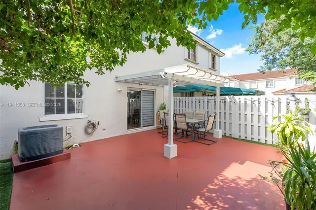 a view of a patio with a table and chairs and potted plants