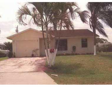 1750 Southeast Monroe Street Stuart, FL 34997 - Photo 1 of 1 a backyard of a house with table and chairs