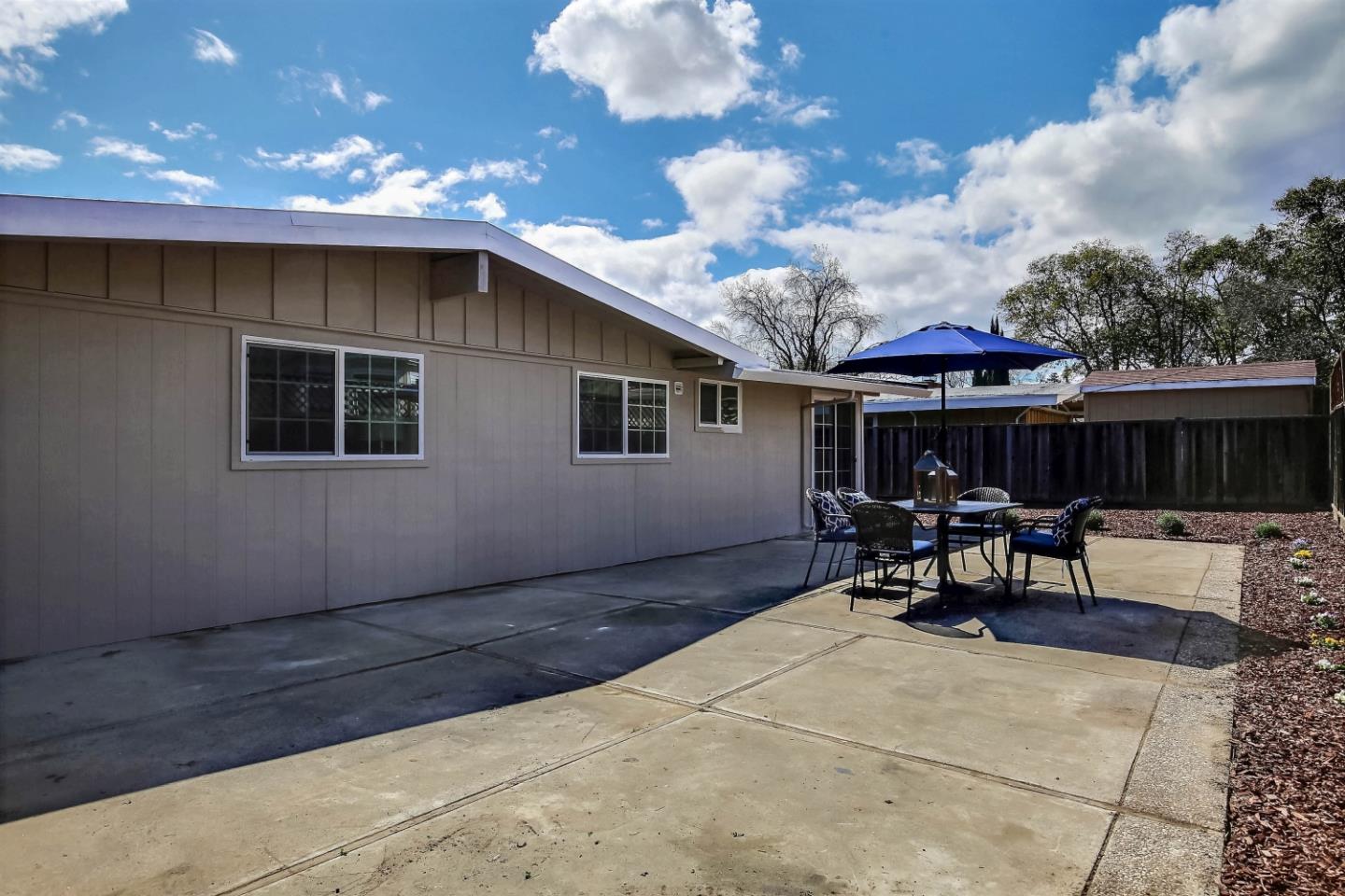 18911 Arata Way Cupertino, CA 95014 - Photo 16 of 18 a backyard of a house with table and chairs