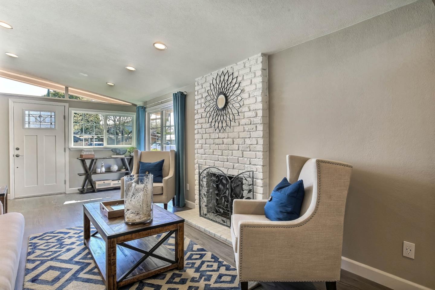 18911 Arata Way Cupertino, CA 95014 - Photo 3 of 18 a living room with furniture a fireplace and a floor to ceiling window
