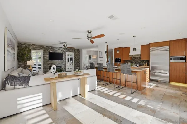 a large white kitchen with sink and stainless steel appliances