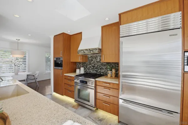 a kitchen with stainless steel appliances granite countertop a sink and a refrigerator