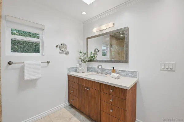 a bathroom with a toilet a sink a mirror and window