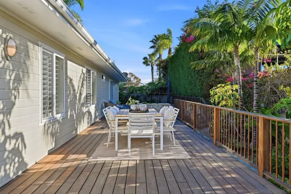 a balcony with wooden floor table and chairs