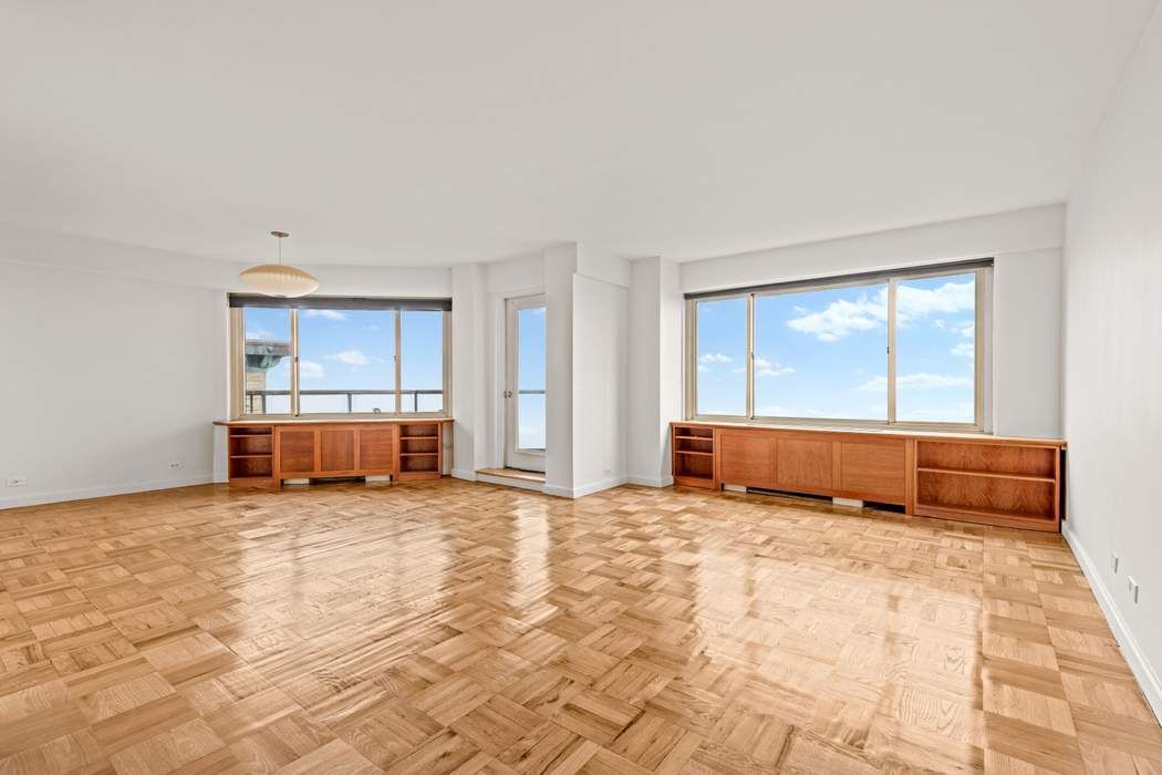 60 Riverside Drive, Unit 19C Manhattan, NY 10024 - Photo 11 of 16 a view of an empty room with wooden floor and a window