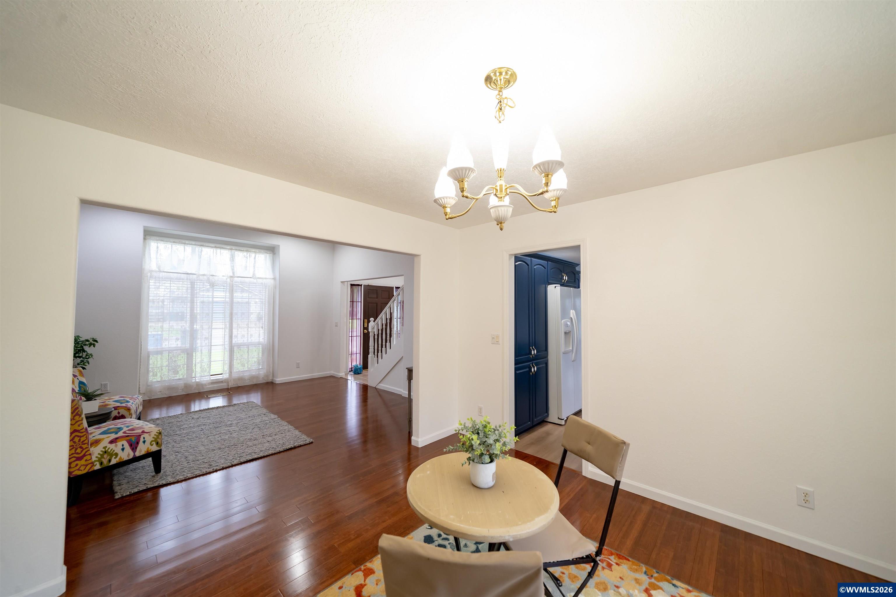 312 Southwest Cascade Meadow Drive Sublimity, OR 97385 - Photo 14 of 42 a dining room with wooden floor and chandelier
