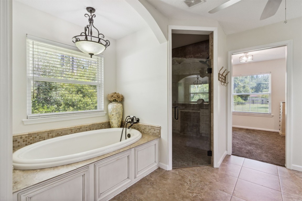 37221 Poole Road Hilliard, FL 32046 - Photo 14 of 67 a white bath tub sitting in a bathroom next to a window