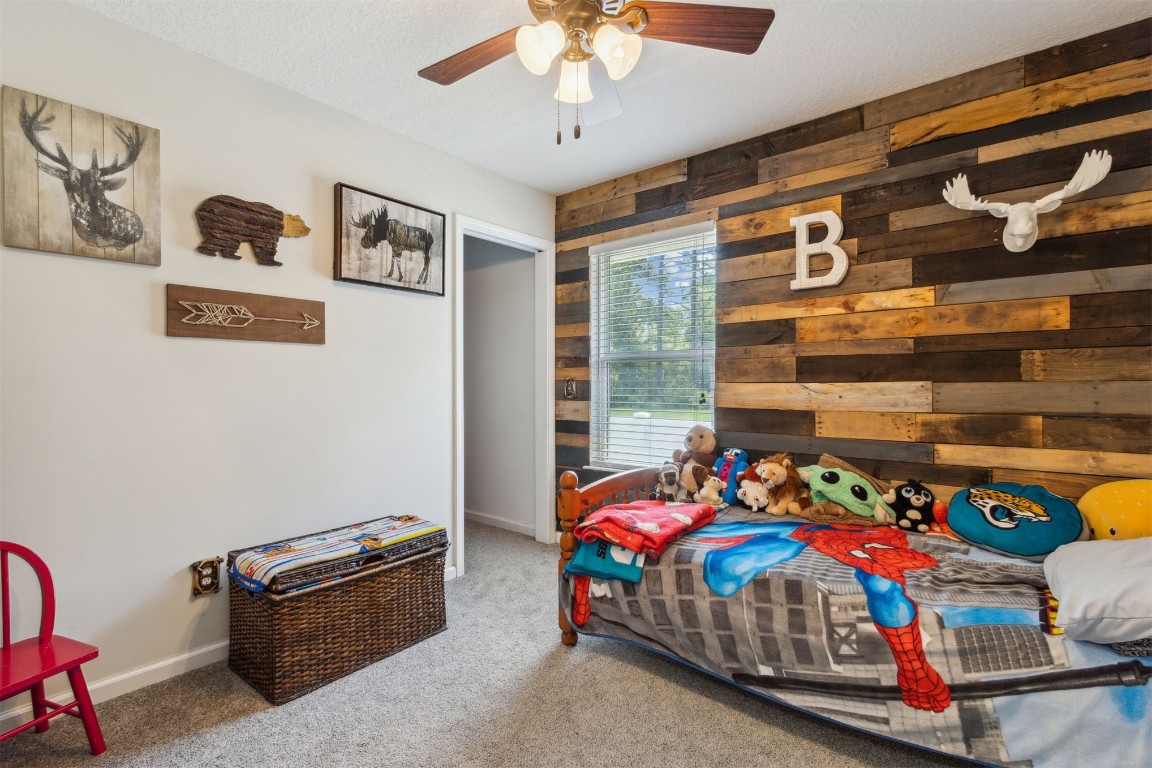 37221 Poole Road Hilliard, FL 32046 - Photo 19 of 67 a bedroom with a bed and a chandelier