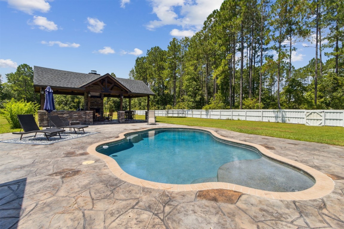 37221 Poole Road Hilliard, FL 32046 - Photo 24 of 67 a view of a swimming pool with an outdoor space and seating area