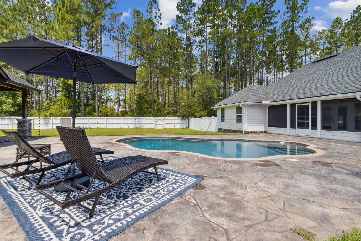37221 Poole Road Hilliard, FL 32046 - Photo 49 of 67 a view of pool with table and chairs under an umbrella