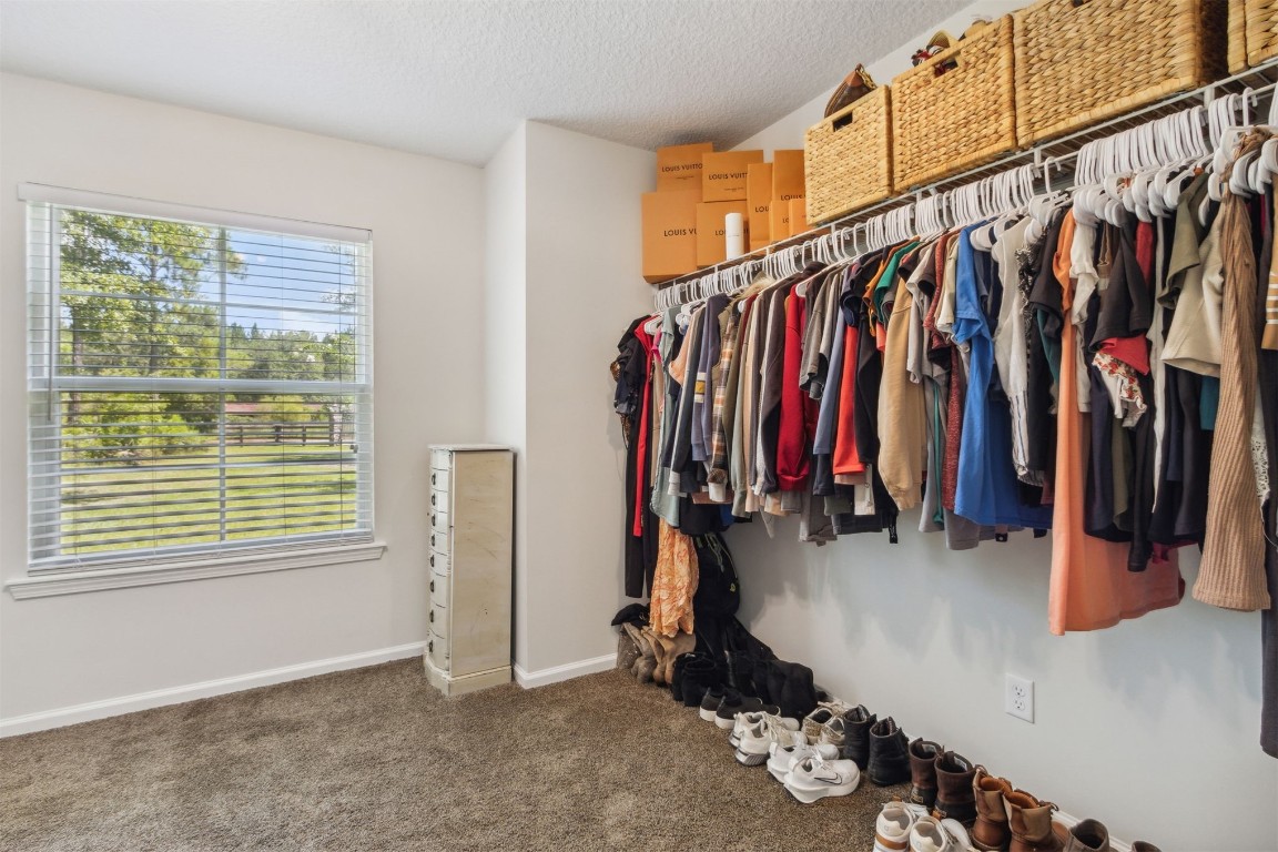 37221 Poole Road Hilliard, FL 32046 - Photo 62 of 67 a view of walk in closet with clothes