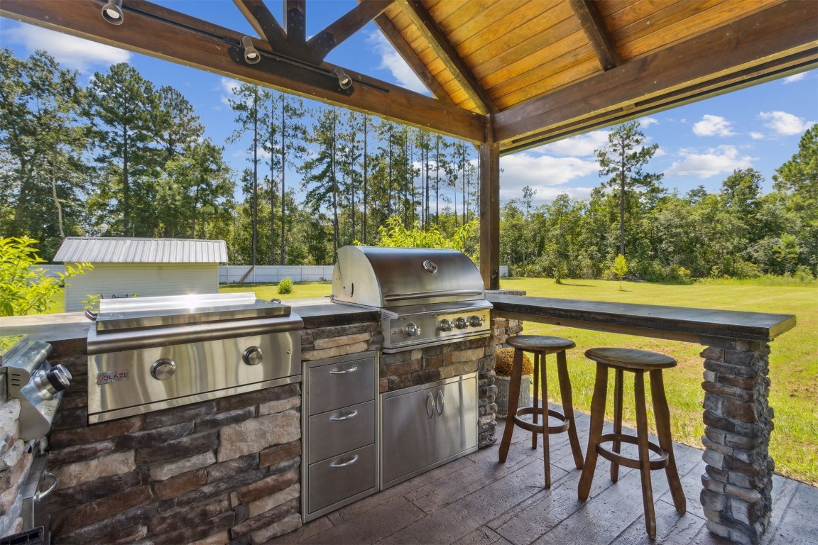 37221 Poole Road Hilliard, FL 32046 - Photo 66 of 67 a view of an outdoor kitchen with a table and chairs