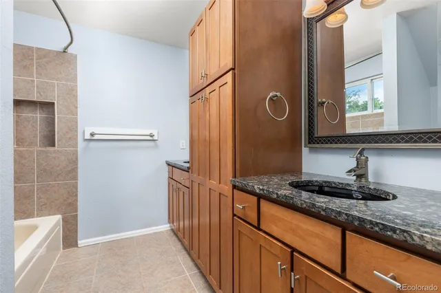 a bathroom with a granite countertop shower a mirror and a sink