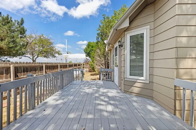 a view of a balcony with wooden floor and fence