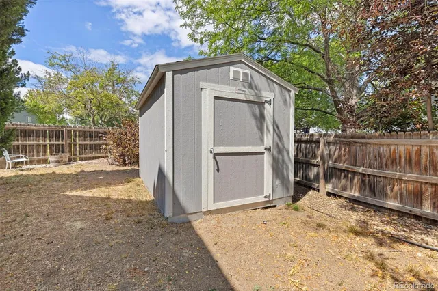 a view of backyard with wooden fence and large trees