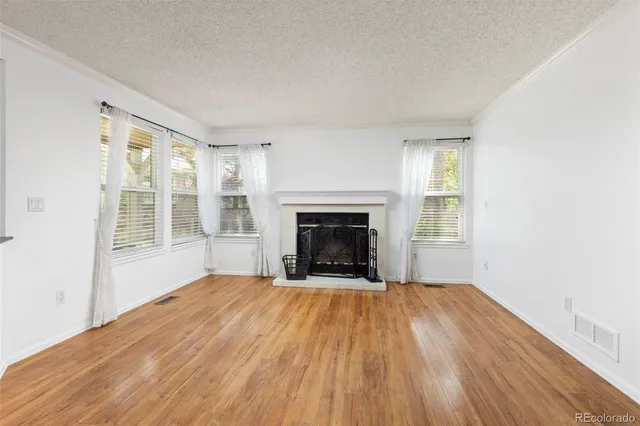 a view of an empty room with a fireplace and a window