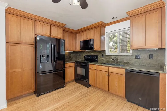 a kitchen with granite countertop a refrigerator stove top oven and sink