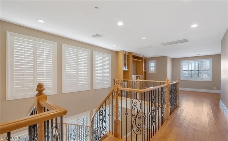 3 Tall Ruff Drive Las Vegas, NV 89148 - Photo 29 of 54 A well-lit landing features intricate ironwork railings, polished hardwood floors, and bright window shutters.