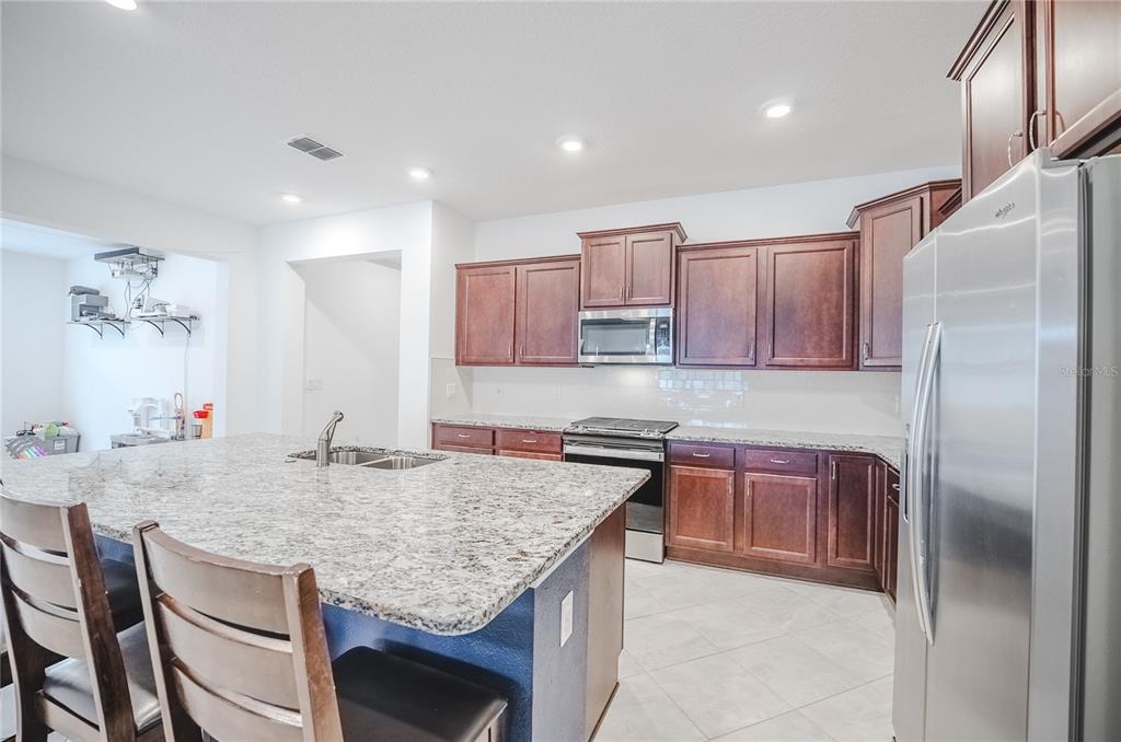 6200 Southwest 72nd Terrace Ocala, FL 34474 - Photo 22 of 70 a kitchen with stainless steel appliances granite countertop a kitchen island a cabinets and wooden floor