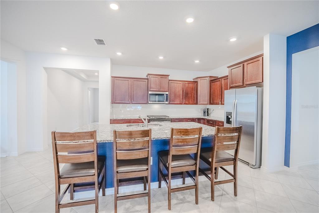 6200 Southwest 72nd Terrace Ocala, FL 34474 - Photo 23 of 70 a kitchen with a dining table chairs refrigerator and cabinets