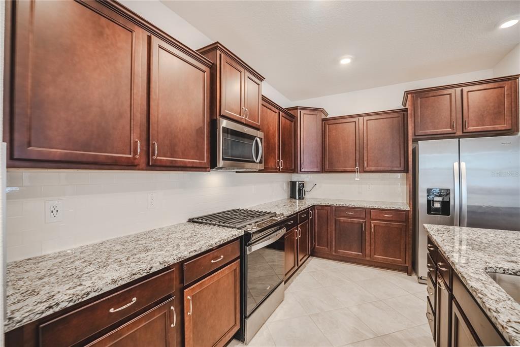6200 Southwest 72nd Terrace Ocala, FL 34474 - Photo 24 of 70 a kitchen with stainless steel appliances granite countertop a sink stove and refrigerator