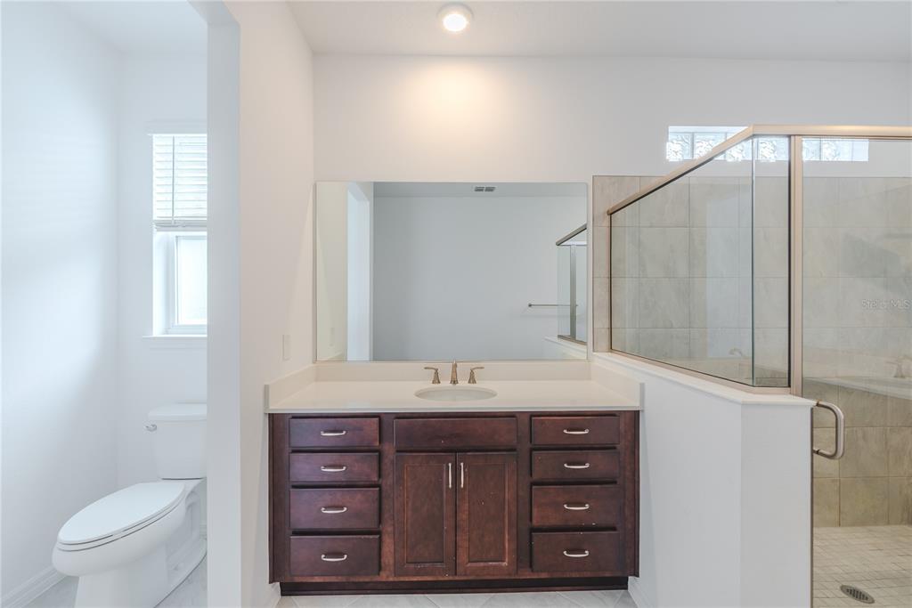 6200 Southwest 72nd Terrace Ocala, FL 34474 - Photo 34 of 70 a bathroom with a granite countertop sink a toilet and a mirror