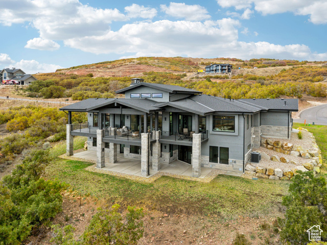 2280 East Outlaw Road, Unit 56 Kamas, UT 84036 - Photo 2 of 59 Back of house with a patio, stone siding, a shingled roof, and a lawn