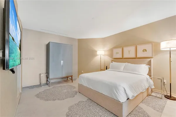 a bedroom with a large bed and a chandelier