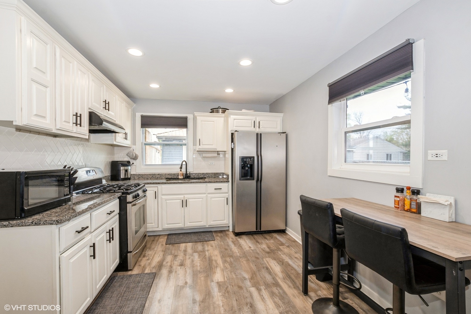 152 Monee Road Park Forest, IL 60466 - Photo 4 of 10 a kitchen with stainless steel appliances granite countertop a refrigerator a sink dishwasher a stove and white countertops with wooden floor