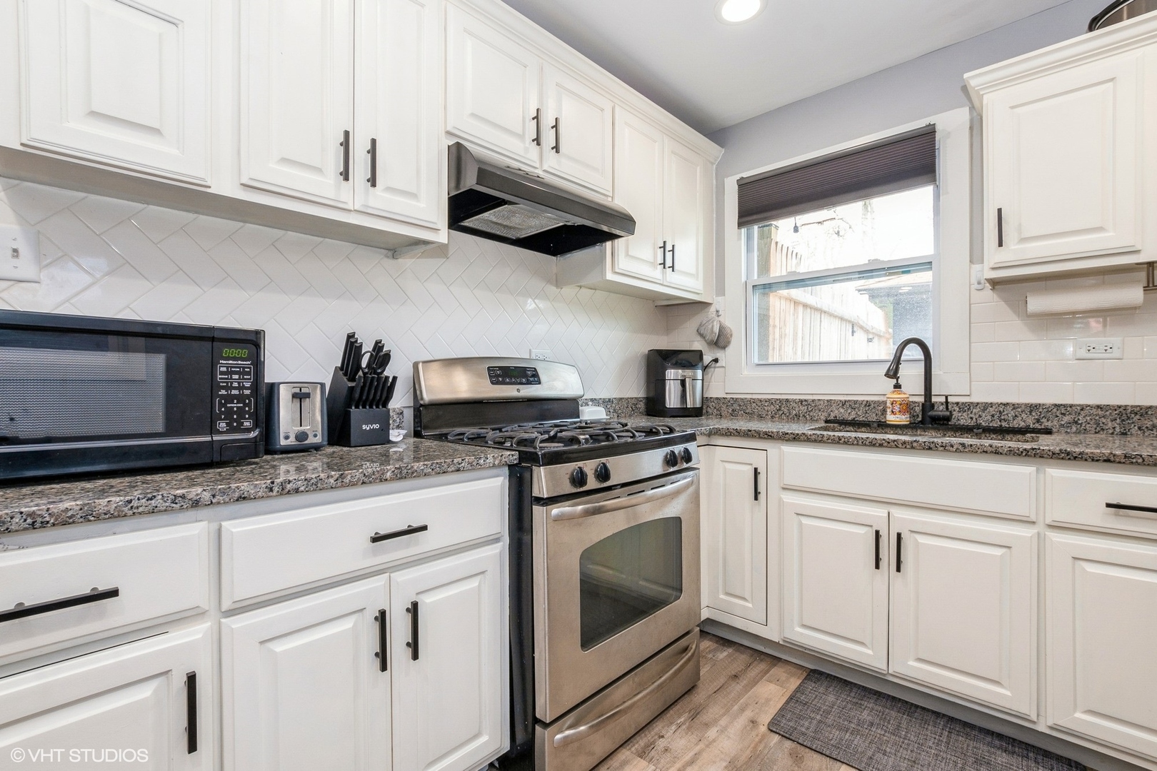 152 Monee Road Park Forest, IL 60466 - Photo 5 of 10 a kitchen with granite countertop white cabinets stainless steel appliances and a window