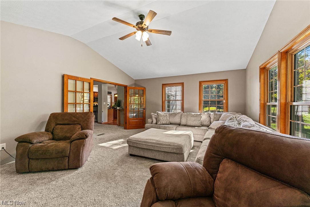 7534 Rice Road Amherst, OH 44001 - Photo 23 of 35 Carpeted living room featuring lofted ceiling and ceiling fan
