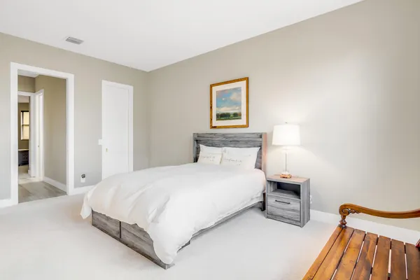 a bedroom with a bed and a painting on the wall