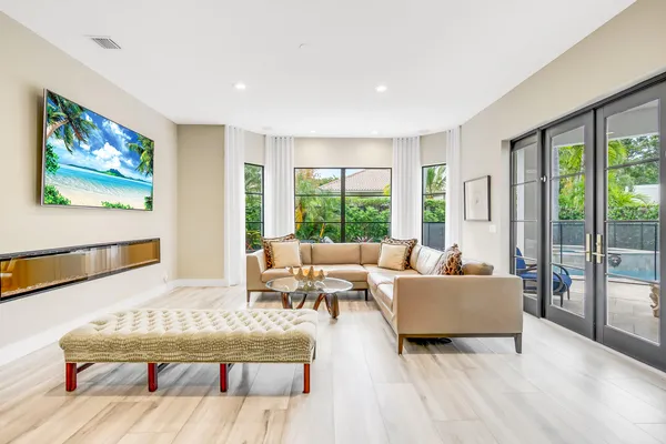 a living room with furniture large window and wooden floor