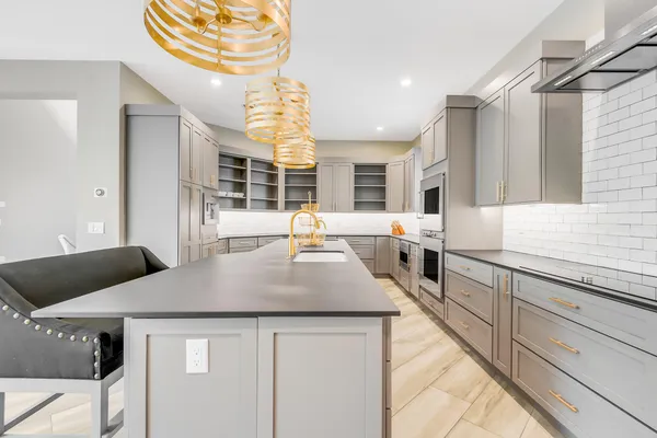 a kitchen with stainless steel appliances granite countertop a sink and a stove