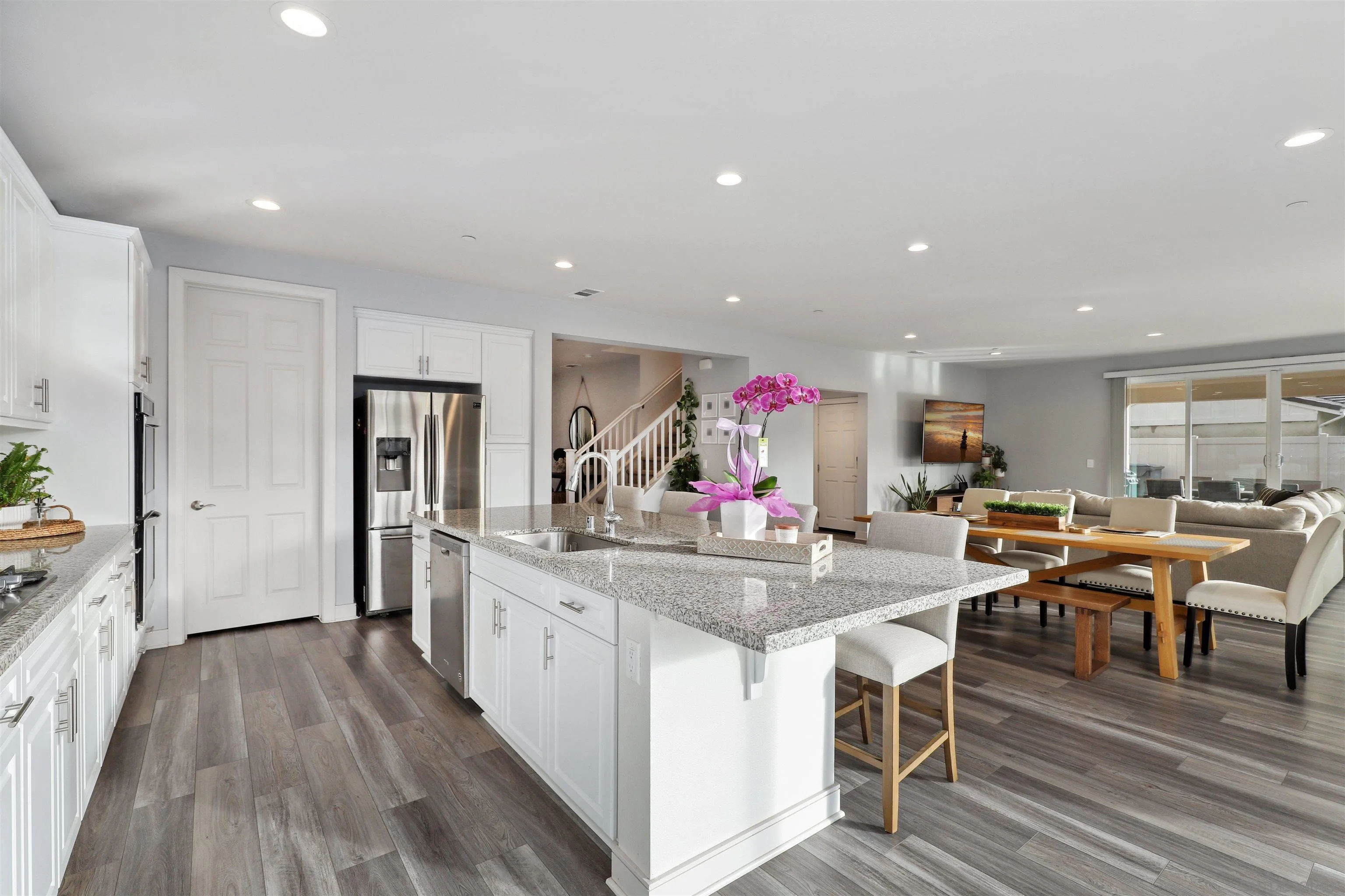 1294 Palomar Circle Escondido, CA 92027 - Photo 14 of 41 a kitchen with stainless steel appliances granite countertop dining table chairs and wooden floor