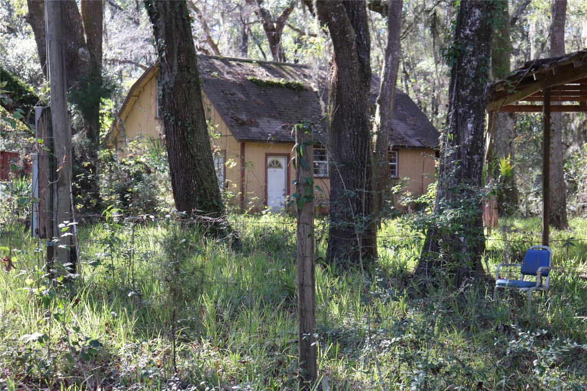 574154 Lessie Road Hilliard, FL 32046 - Photo 11 of 34 a backyard of a house with lots of plants and trees